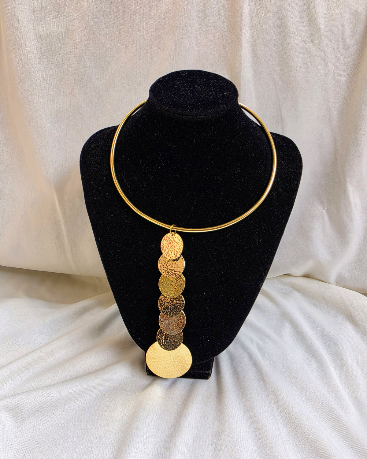 Mumbi Necklace - hammered gold disc drop necklace on gold torque collar, product shot