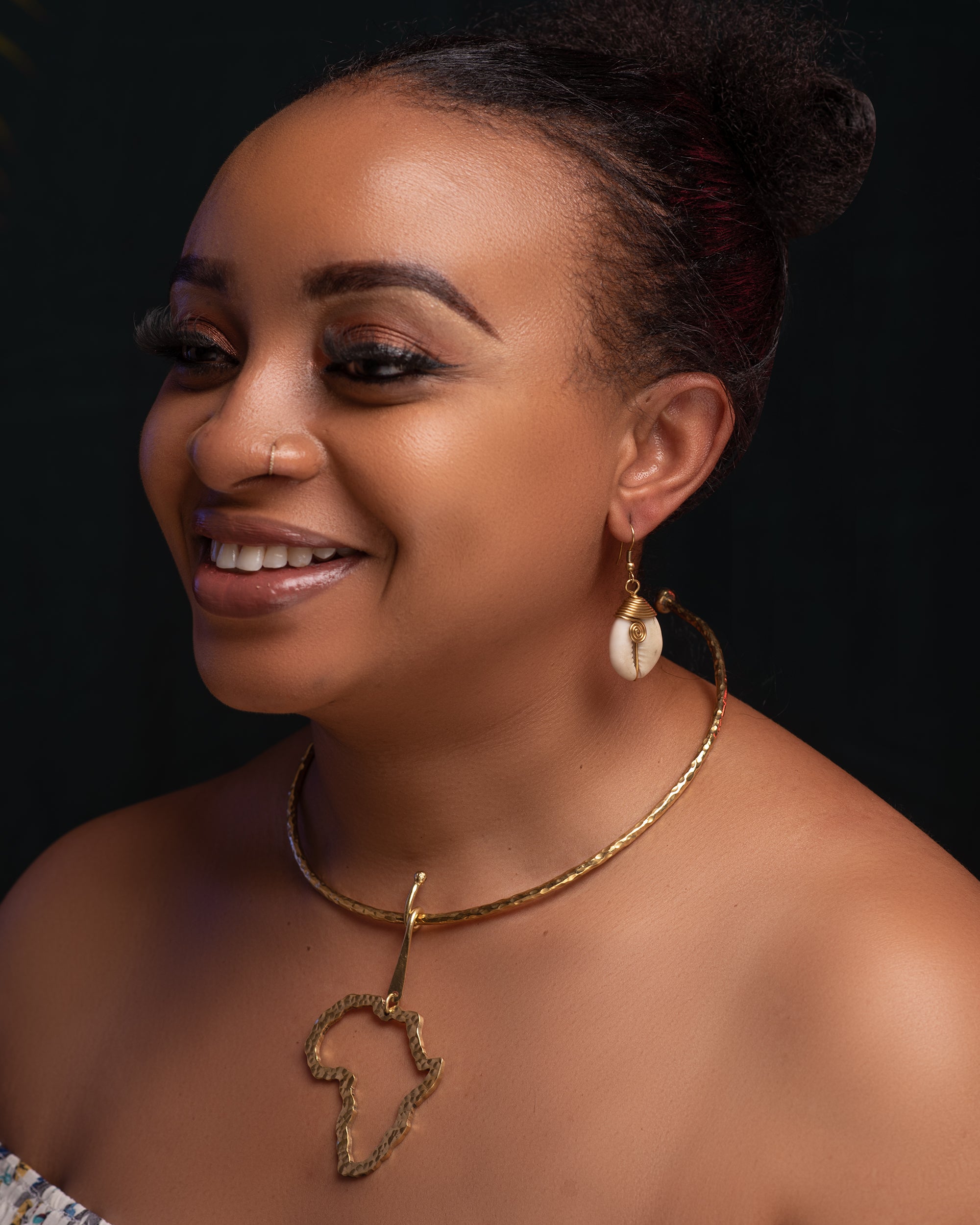 Africa Moja Outline Necklace - brass Africa map pendant on twisted collar, handmade in Kenya, worn with cowrie shell earrings