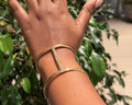 Ndare Bangle – hammered brass rectangular frame cuff worn on wrist, back view showing open frame