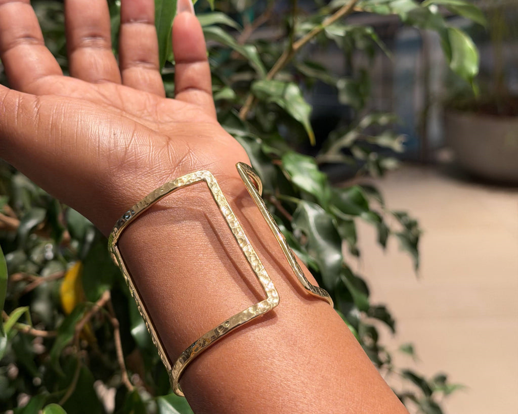 Ndare Bangle – hammered brass rectangular frame cuff worn on wrist, front view