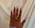 Malkia Ring - gold serpentine wrap ring with green accent worn on hand