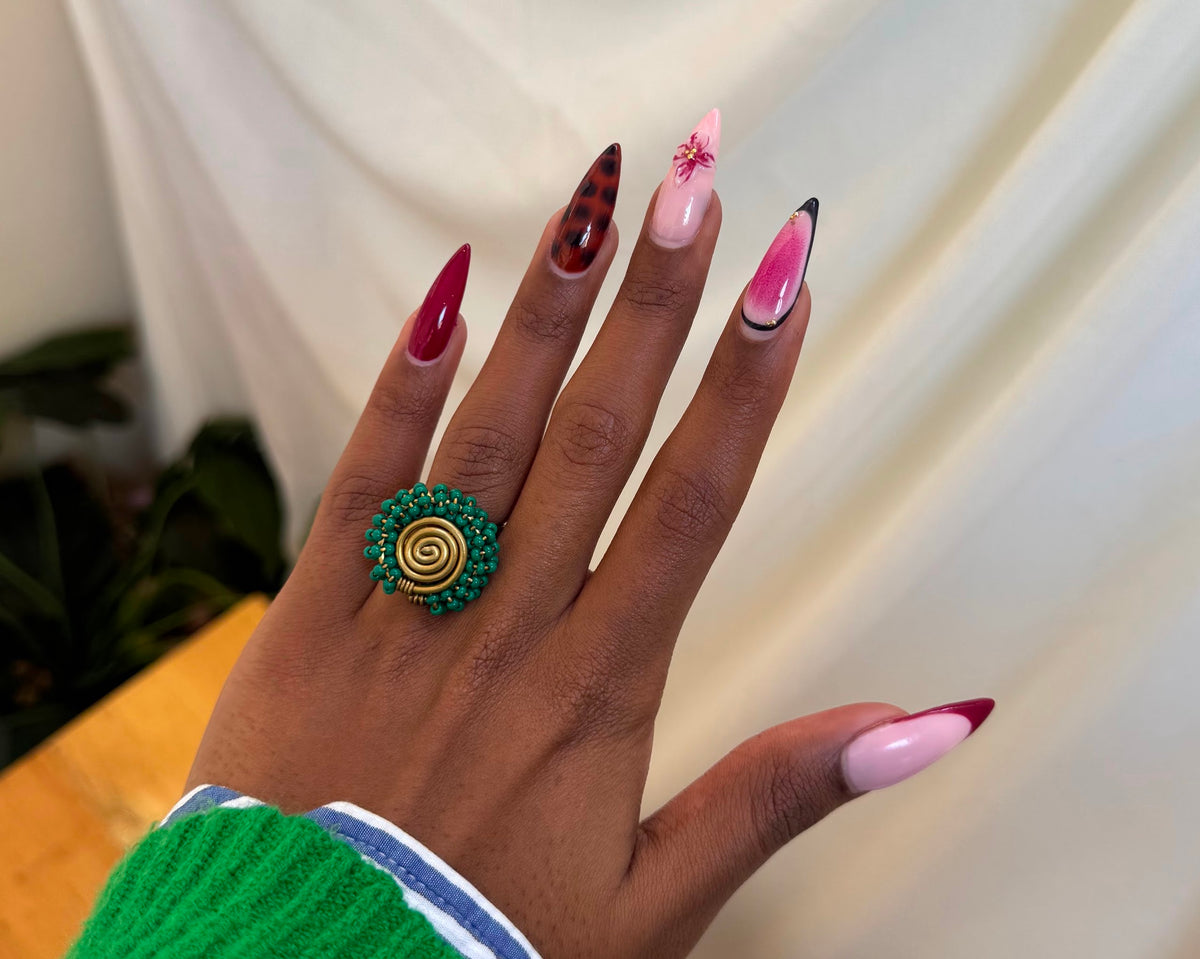 Nuru Ring Green - circular beaded ring with spiral gold centre and green seed beads worn on hand