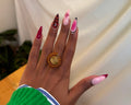 Nuru Ring Brown - circular beaded ring with spiral gold centre and amber-brown seed beads worn on hand